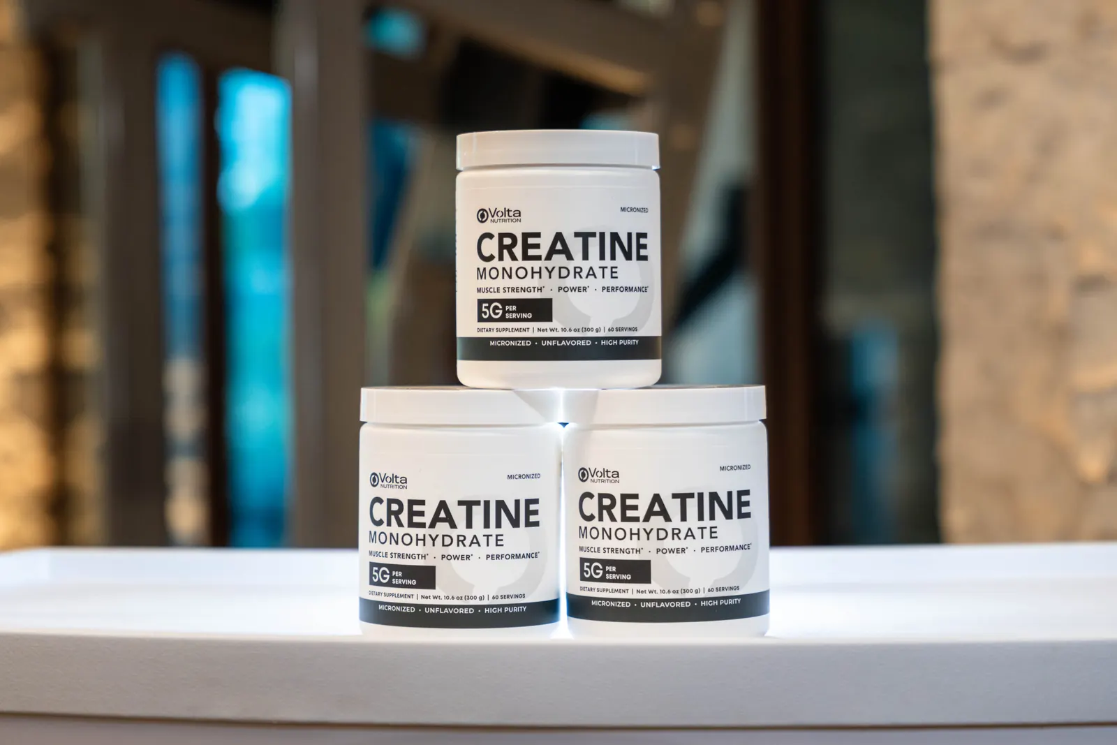 Tres botes de Volta Creatine apilados sobre una mesa blanca